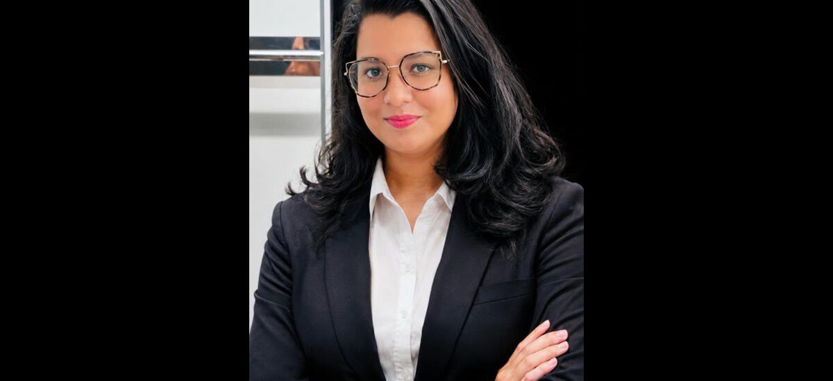 Aghila Anilkumar, Logistics and Supply Chain Management MSc graduate. She is wearing a black suit jacket over a white shirt, nad has her arms crossed while looking at the camera.