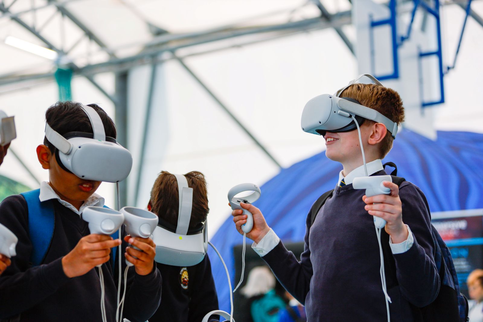 Three boys wear virtual reality headsets at Steam Northants 2025.