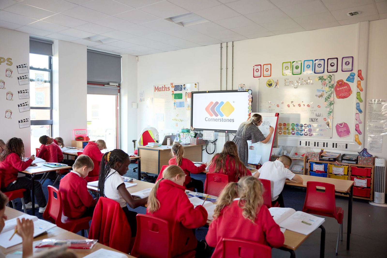 A teacher writes on a flipchart during a lesson in a classroom.