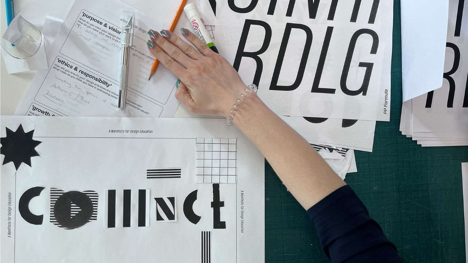 Graphic Design student developing typography and layout concepts using printed design experiments, paper prototypes and workshop materials.