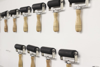 Handheld ink rollers attached to a wall