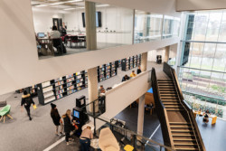 First floor of the University of Northampton library, with books and staircases, full of students walking around