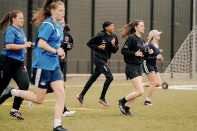 Students running on a football field