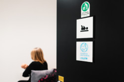 Open door to the baby nappy changing and breastfeeding room, demonstrated by a person holding a baby manikin