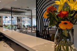 Flowers on the front desk at Sunley hotel. In the background the breakfast area can be seen.