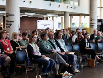 View of approximately 30 delegates sitting in rows at the UON Sustainability Summit 2023, they are looking off camera presumably towards a screen and speaker.