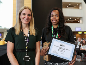 Professor Anne-Marie Kilday, Vice Chancellor, presenting the Sustainability Awards 2023 from the UON Sustainability Summit 2023 to a representative from The Lewis Foundation for Best Social Initiative. They are both smiling and looking at the camera.