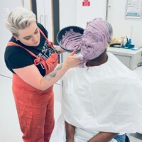 Senior Lecturer in Occupational Therapy Dr Nickey Hardy is pictured with his face completely covered in the mixture that will form the mould to create a silicone mask by Technician Demonstrator Poppy Twigger (also pictured).