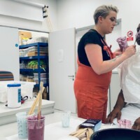 Technician Demonstrator Poppy Twigger is seen in the Hair, Make-Up and Prosthetics for the Stage and Screen studio applying a mixture to Nickey Hardy’s face to help her create the silicone mask