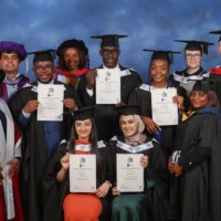 Public Health graduate and student award winner Marshal Mutai is pictured holding his certificate alongside his academics.
