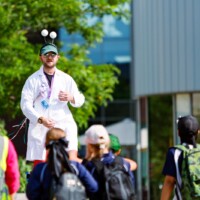 a circus performer on stilts greets guests at STEAM Northants 2025.