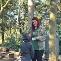 Environment Advisor Hollie Darby speaking to a student with their hood up.