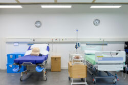 Midwifery skills laboratory where simulated teaching occurs featuring a hospital-style bed, baby cot, and clinical training equipment used for teaching maternal, newborn, and postnatal maternal, fetal and neonatal care within the antenatal, intrapartum and postnatal period.