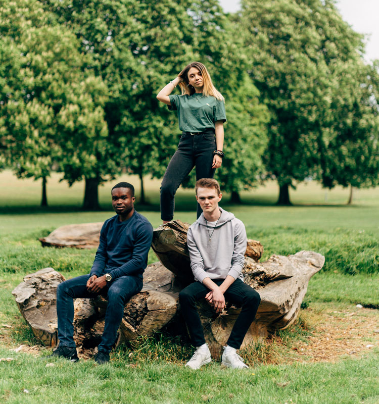 Three students on a log at Becket's Park in Northampton.