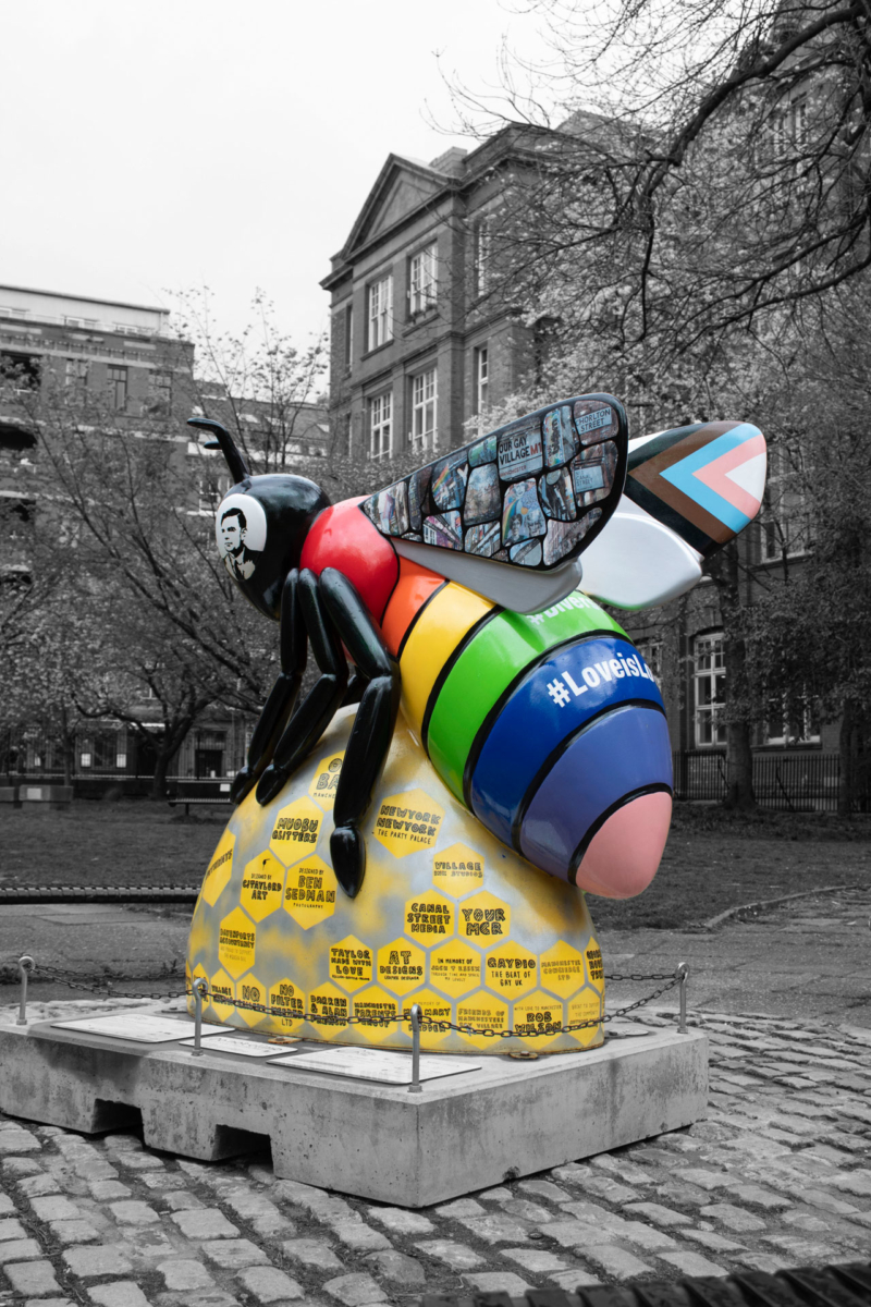 Giant Bee statue with various LGBTQ+ flags on it